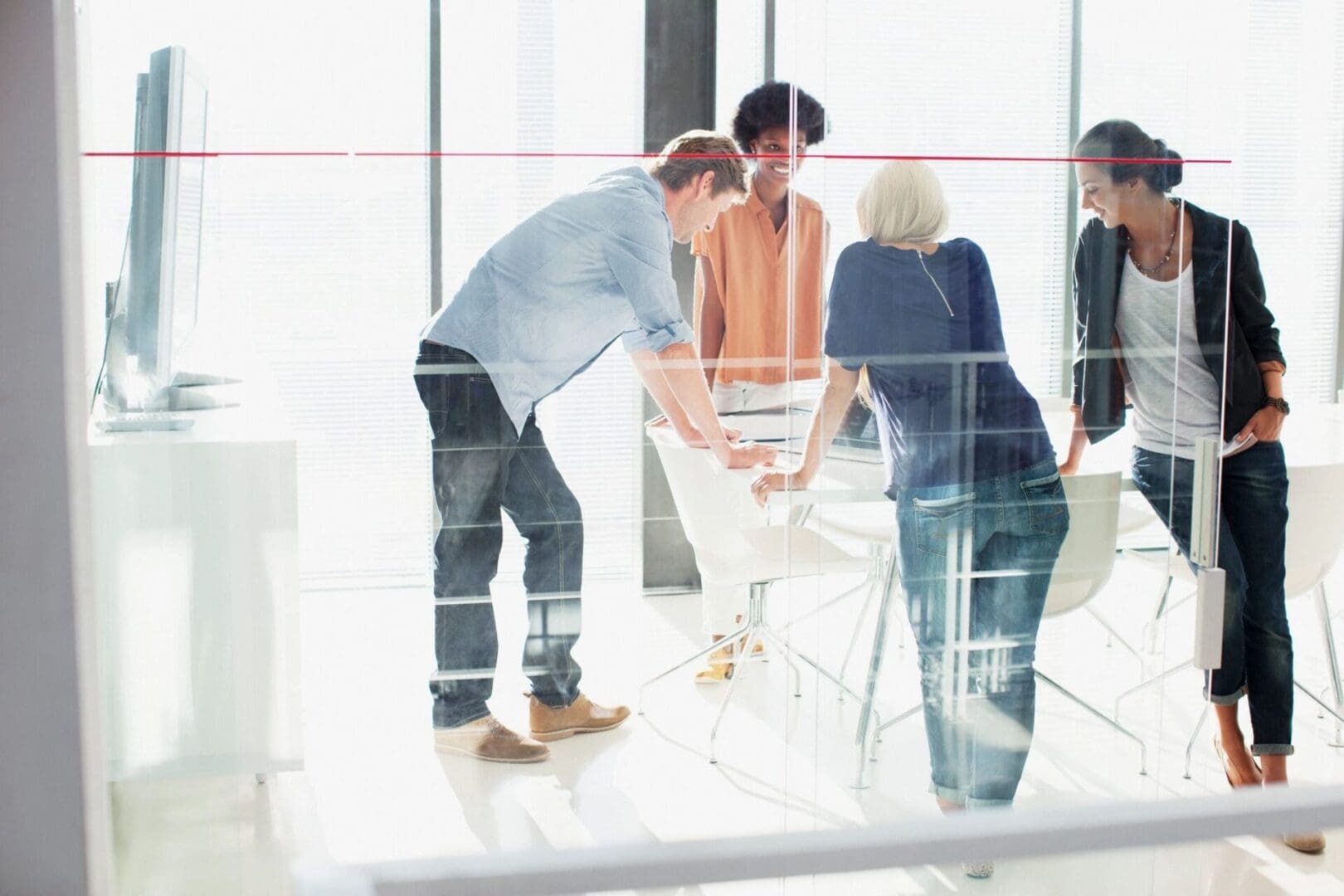 A group of people standing around in an office.